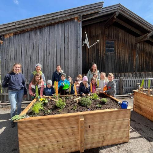 Fertiges Hochbeet mit Schulkindern und Lehrern