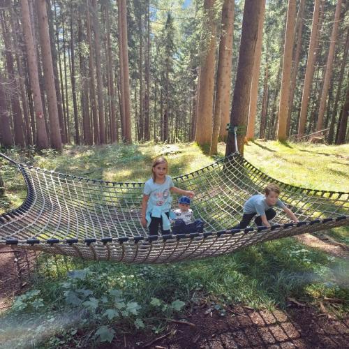 Kinder auf einem Spielnetz auf dem Waldspielplatz