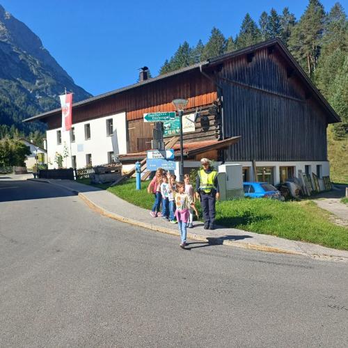 Schülergruppe mit Polizistin an einer Straße 