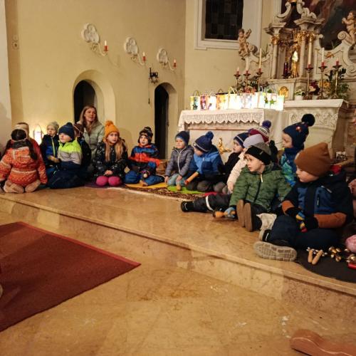 Kinder sitzend beim Altar in der Kirche