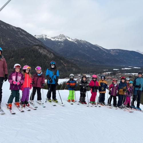 Gruppe von Schülern in Schiausrüstung am Schihang