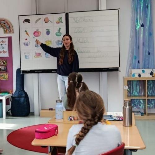 Vortragende vor weißer Tafel im Klassenzimmer