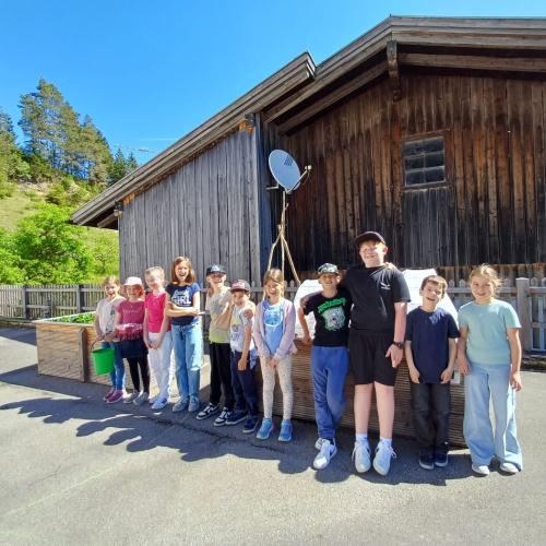Kinder stehen als Gruppe vor Hochbeet