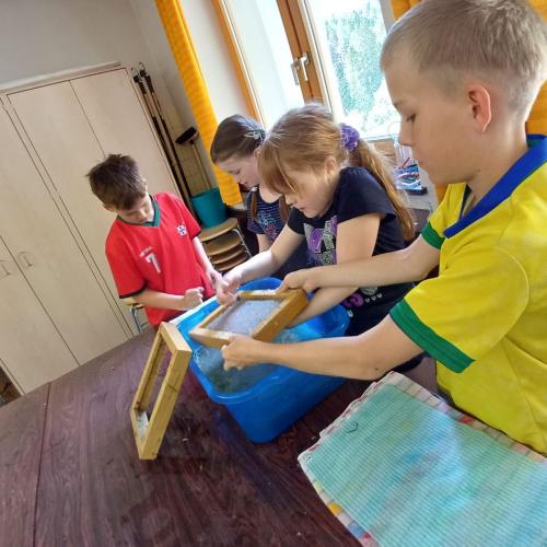 Kinder beim Papier schöpfen