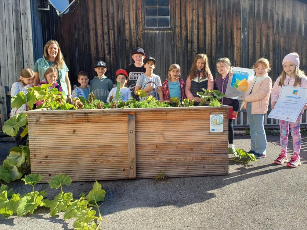Gruppenfoto einer Schulklasse vor einem Hochbeet