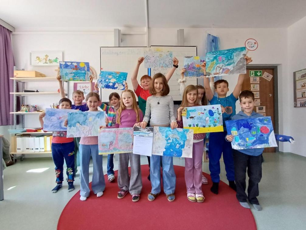 Gruppe von Kinder mit Zeichnungen in der Hand in der Schulklasse