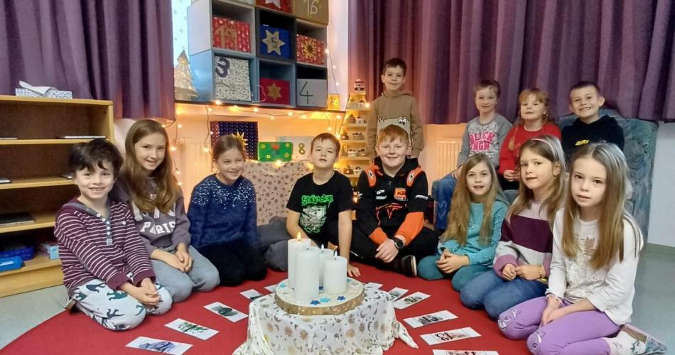 Kinder sitzen im Halbkreis in der Klasse