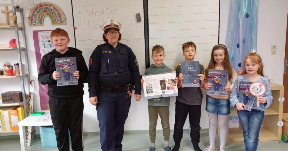 Kinder der 3. und 4. Schulstufe mit einer Polizistin