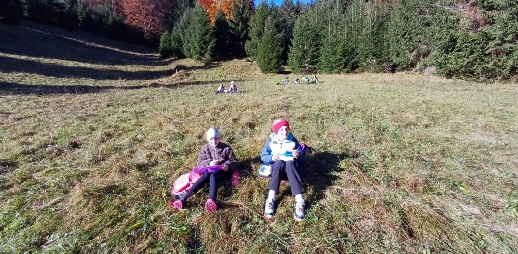 Kinder sitzen auf der Wiese und jausnen.