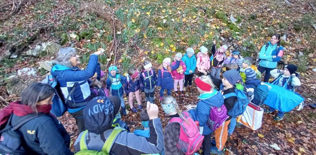 Kinder sitzen auf der Wiese und jausnen.